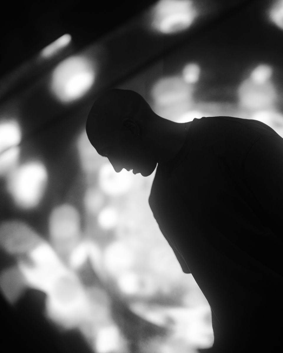 Factor Eight in silhouette against projected light