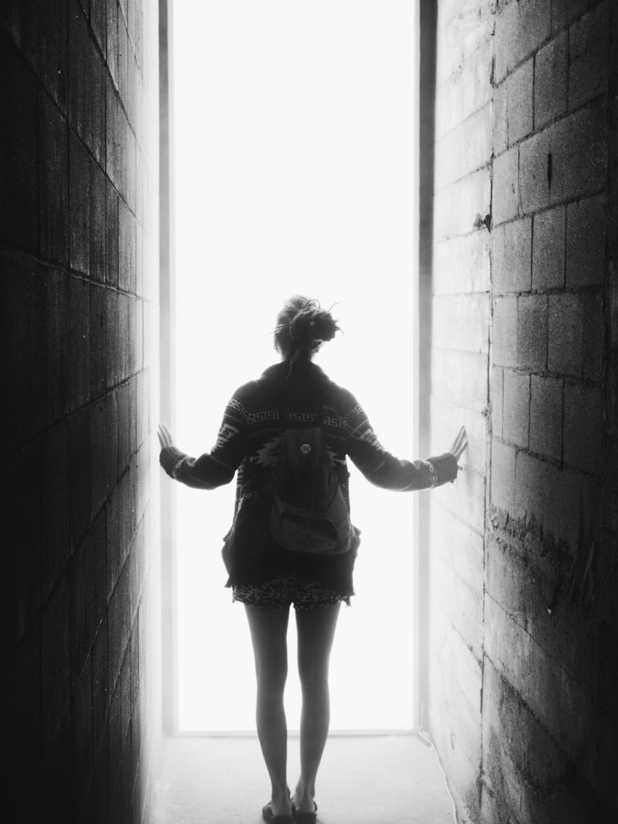 A visitor with arms out in the light