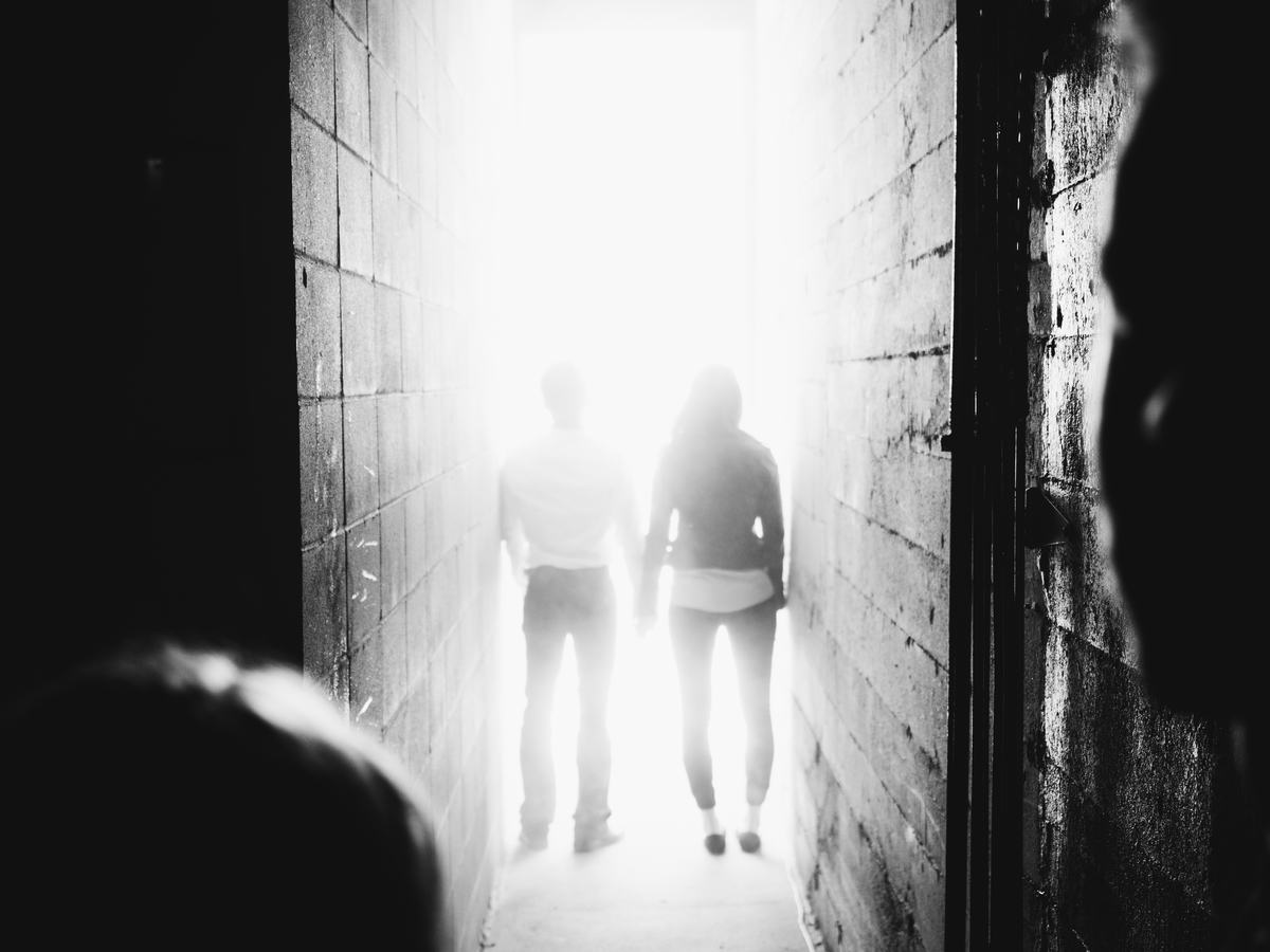 Two visitors walking into the light