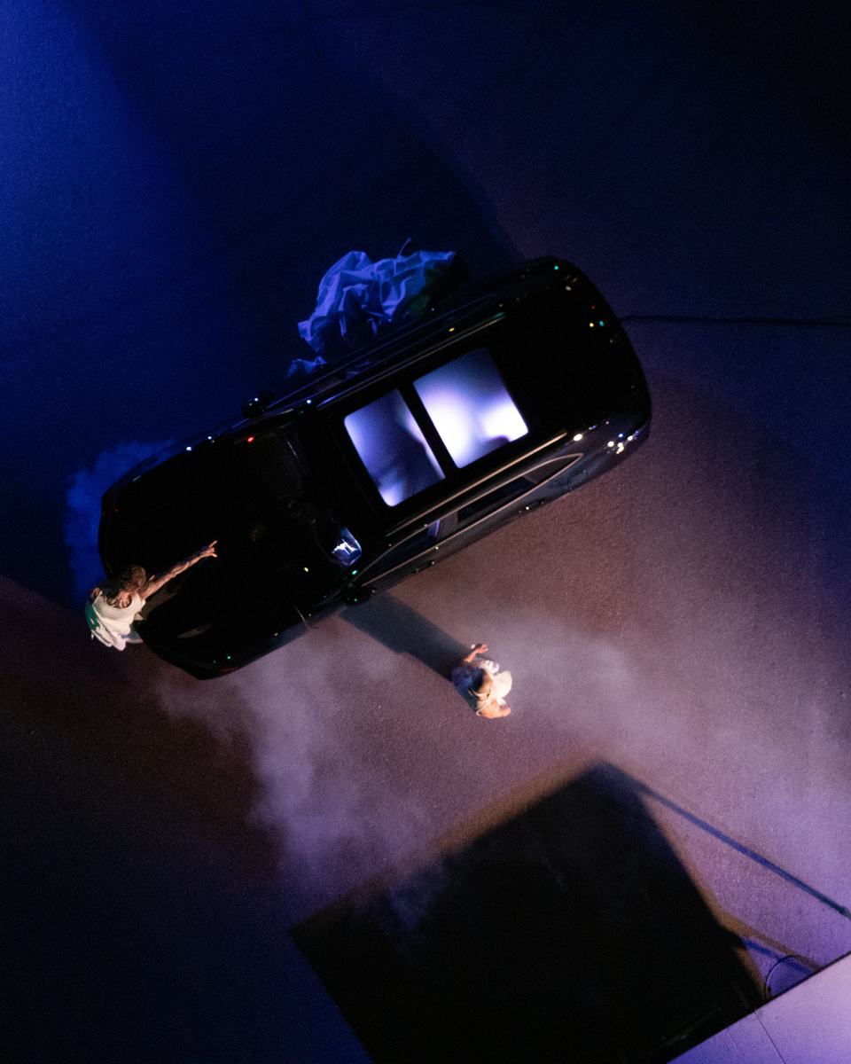 Looking straight down on the car, the dancers and the haze